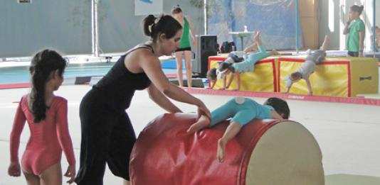 Le professeur aide les enfants à franchir un tapis cylindrique